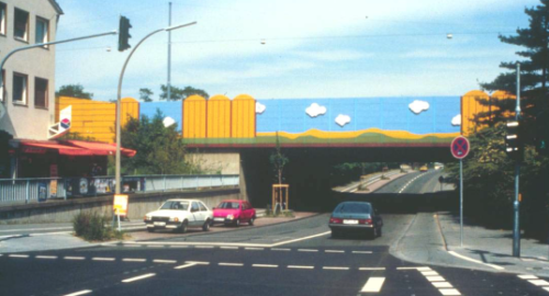 Figur  6: Støyskjerm som et fargerik urbant tiltak der hovedvei 555 passerer over en bro over en lokal vei i T