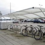 Linkende bilde av sykkelstativ ved en parkeringsplass.