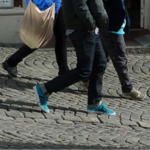 bena til mennesker som går på brostenbelegning.