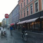 av syklister som sykler i sykkelgate i et bymiljø.