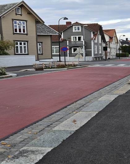 Fotoene viser utforming av den sykkelprioriterte gaten i Stavanger. Asfalten er r&oslash;d, og g&aring;r gjennom et omr&aring;de med trehusbebyggelse.