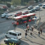 bilde av gatekryss med gangfelt og en gruppe mennesker som går fra en bussholdeplass.