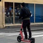 toet viser en mann som står på en elektrisk sparkesykkel.