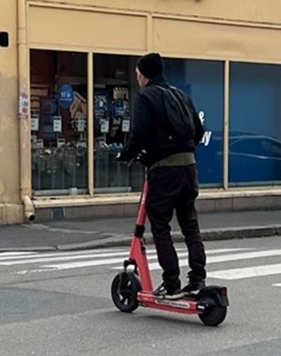 toet viser en mann som st&aring;r p&aring; en elektrisk sparkesykkel.