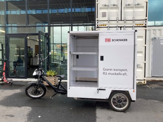 Fotoet viser en lastesykkel som benyttes av DB Schenker. Lasteenheten er åpen så en ser hyllesystemet inne i lasteenheten.
