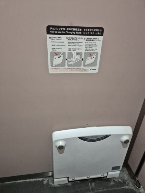 Bildet viser et toalett som har et brett festet p&aring; veggen. Brettet kan b&oslash;yes ned og brukes til &aring; st&aring; &aring; skifte p&aring; dersom man har behov for dette.