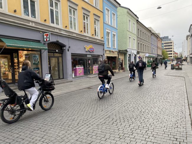 Fotoene viser syklende i Torggata i Oslo. Veibanen er belagt med brostein.