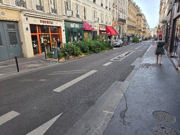  De to fotoene viser utformingen av sykkelgate i Paris. Det er tydelige markeringer i asfalten for &aring; markere at dette er en sykkelgate.